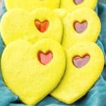 stained glass cookies on a baking tray covered with a kitchen towels.