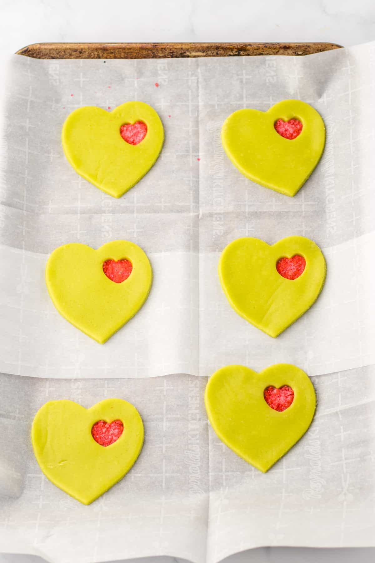 raw stained glass cookies on a parchment lined baking sheet.