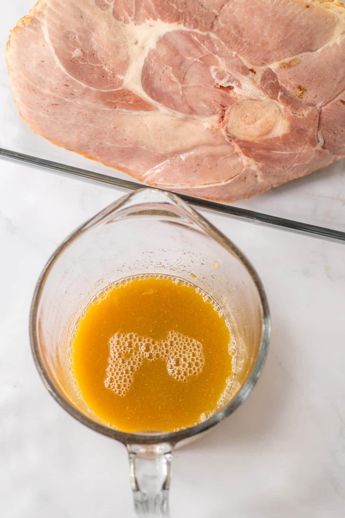 pineapple glaze being mixed in a glass measuring cup.