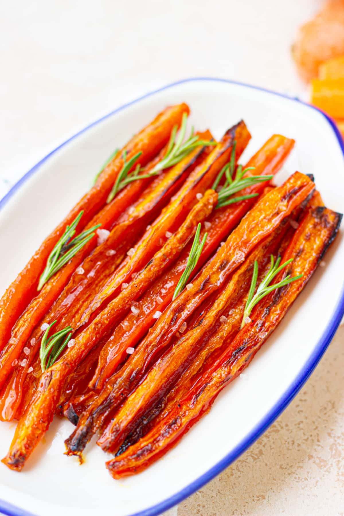maple glazed roasted carrots garnished with parsley on a plate.
