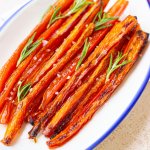 maple glazed roasted carrots garnished with parsley on a plate.