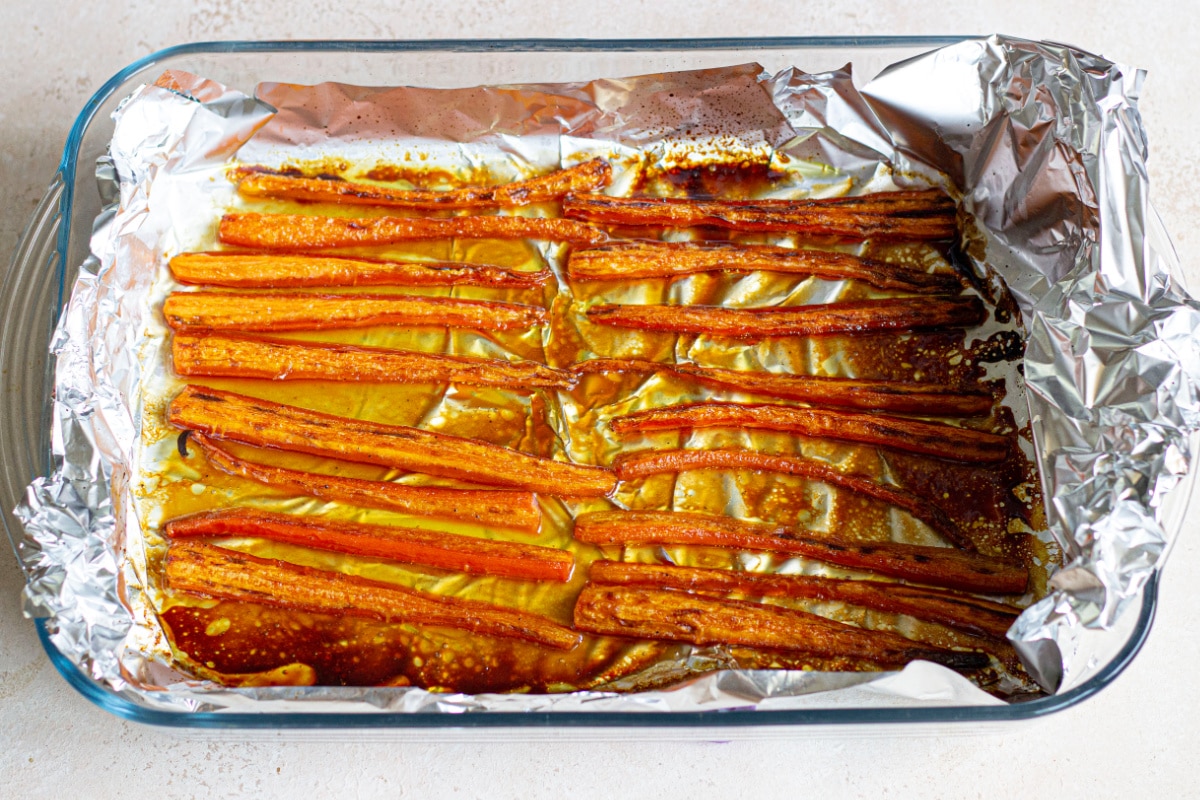 maple glazed roasted carrots in a foil lined baking dish.