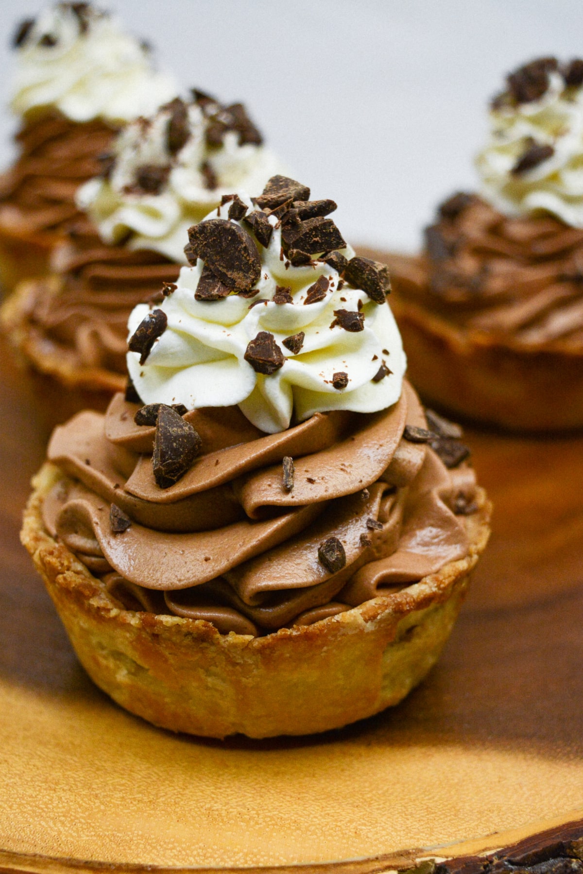 mini chocolate silk pie on a wooden board.