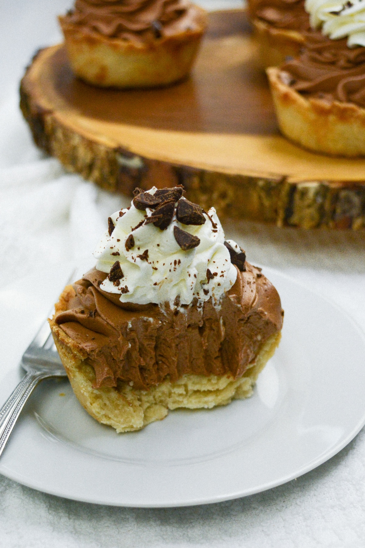 mini chocolate silk pie on a plate with a bite missing.