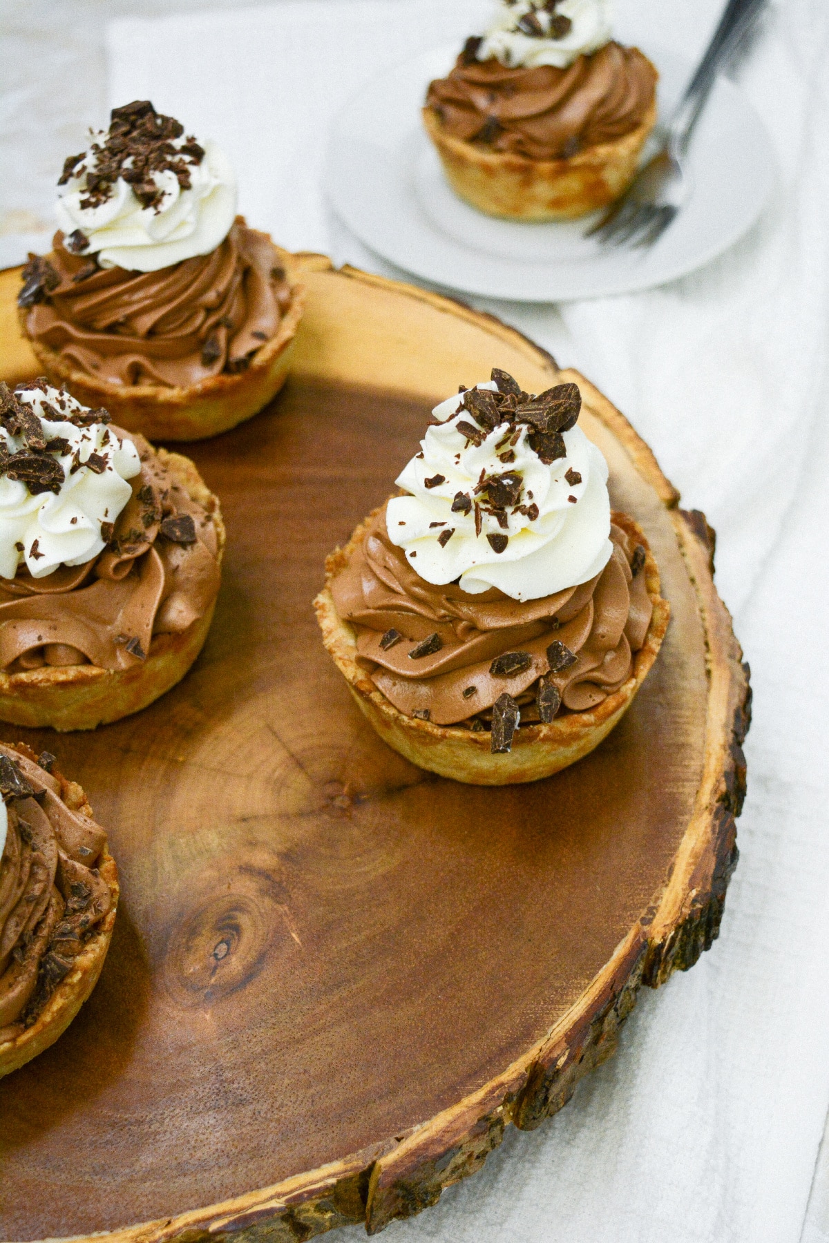 mini chocolate silk pies on a wooden cutting board.