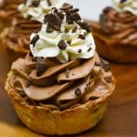 mini chocolate silk pie on a wooden board.