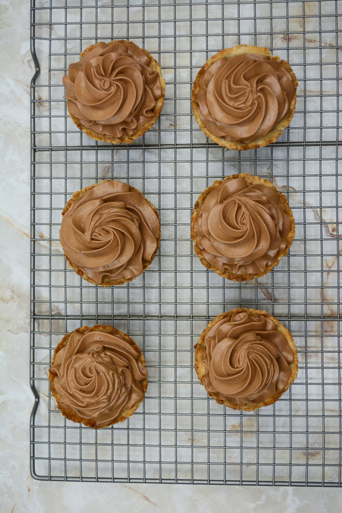 pie shells being filled on a cooling rack.