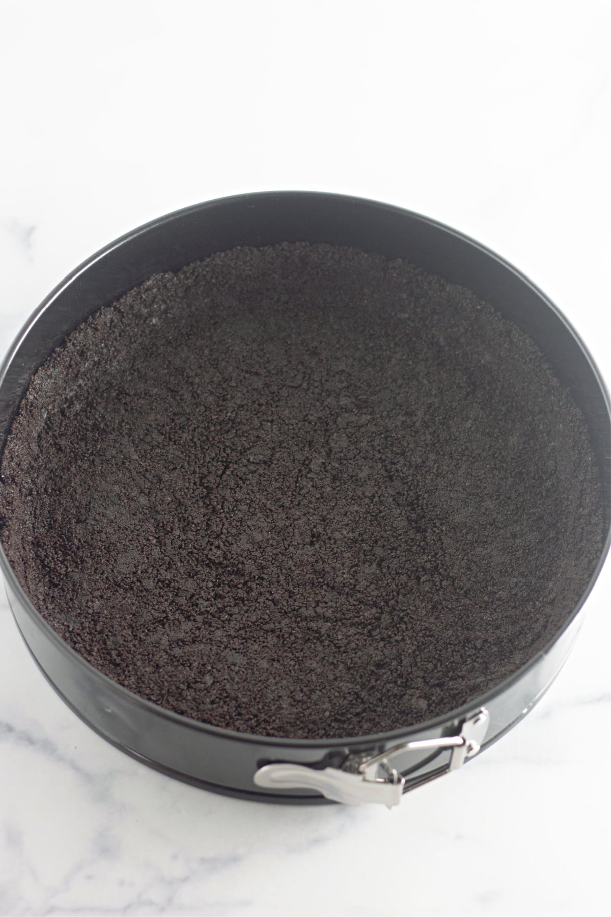 oreo cookie crust pressed into the bottom of a springform pan.