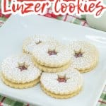 raspberry linzer cookies stacked on a plate.