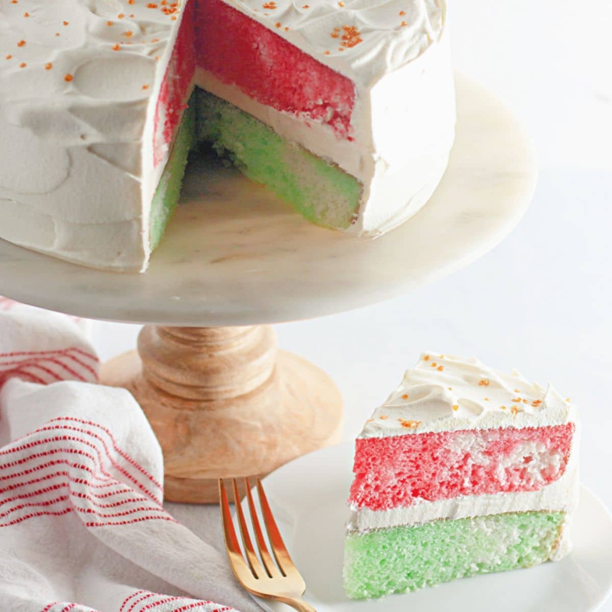 slice of red and green christmas cake on a white plate.