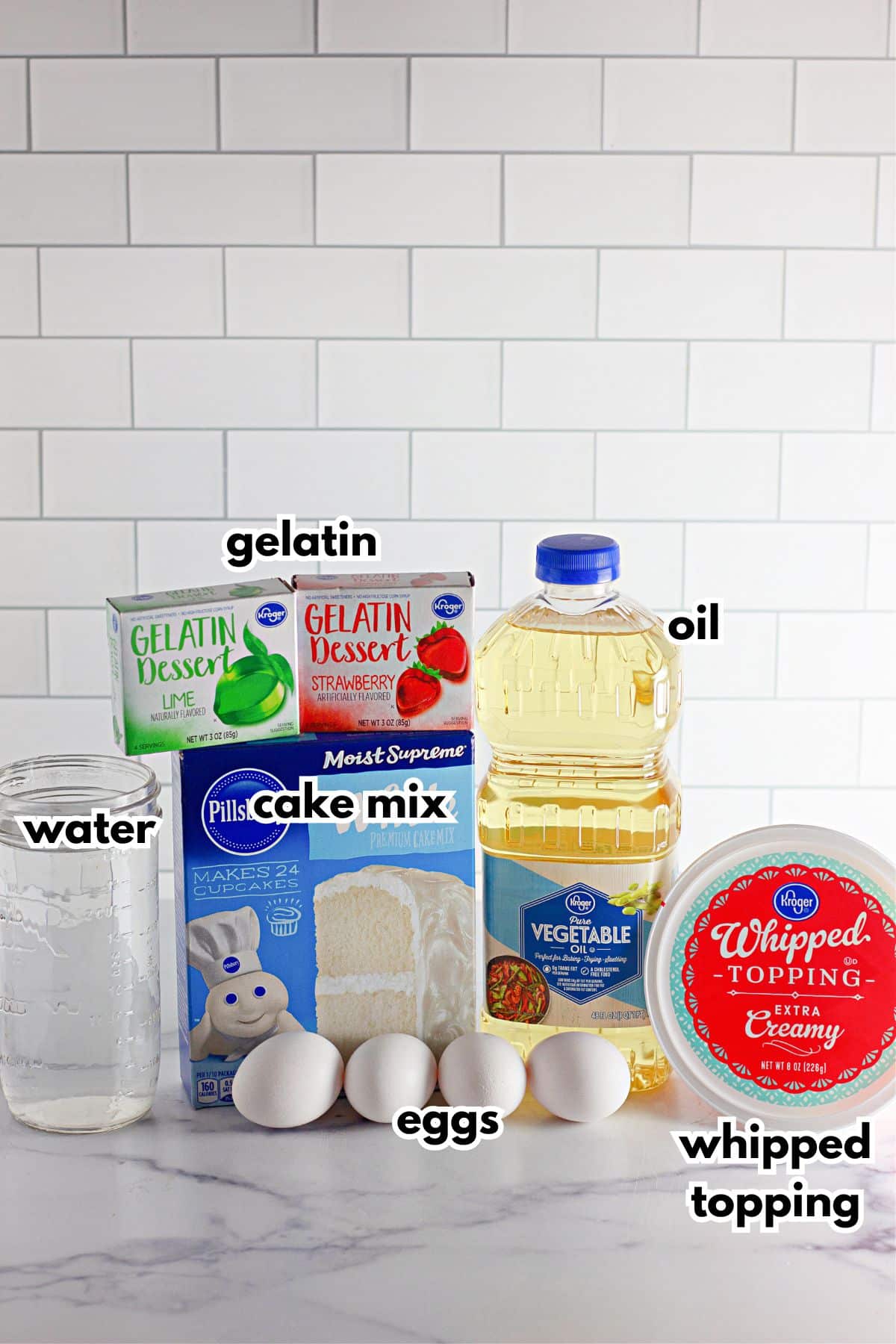 boxes of cake mix, gelatin mixes, bottle of oil, eggs, whipped topping and water.