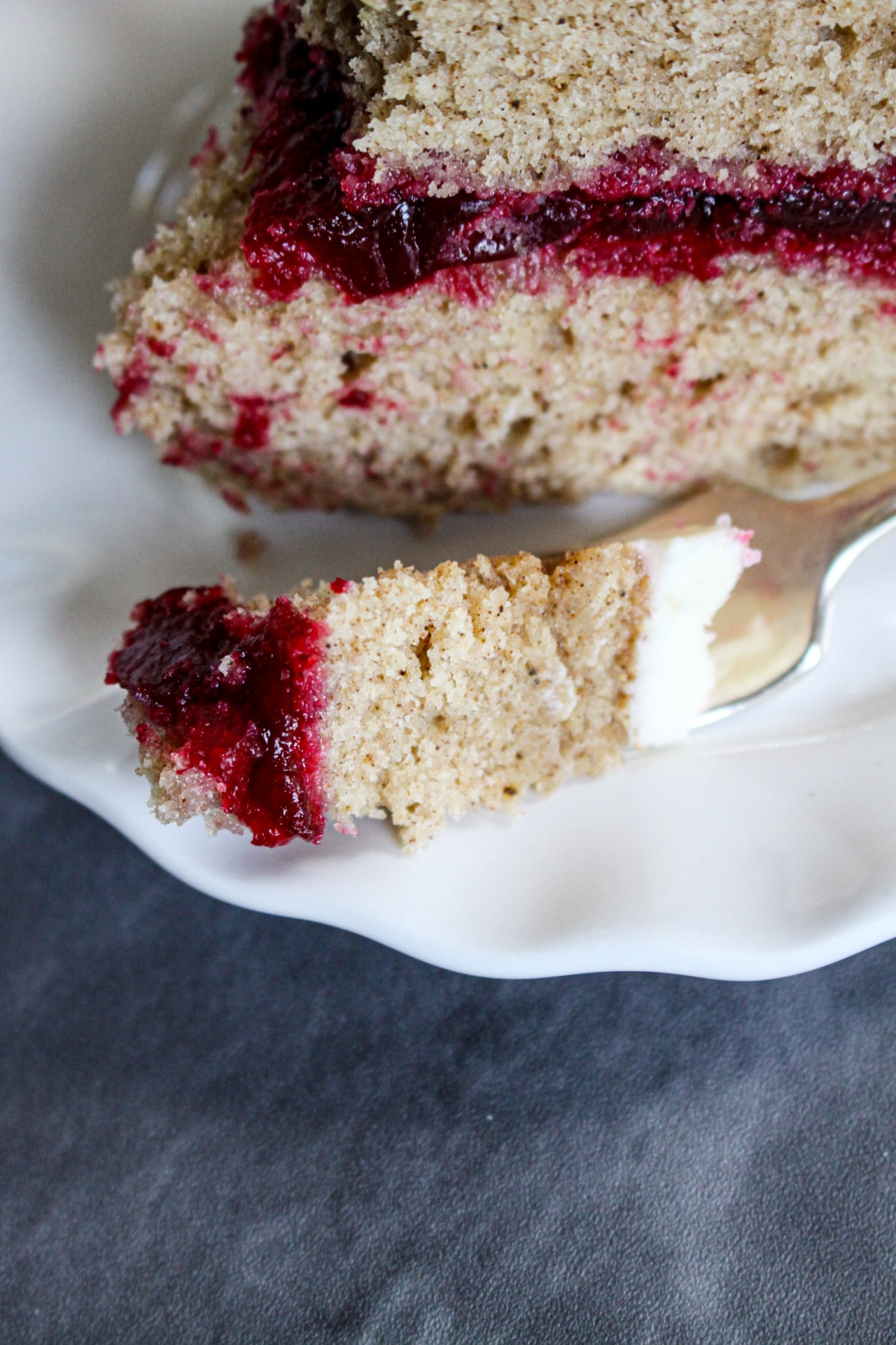 bite of spice cake with cranberry filling on a fork.