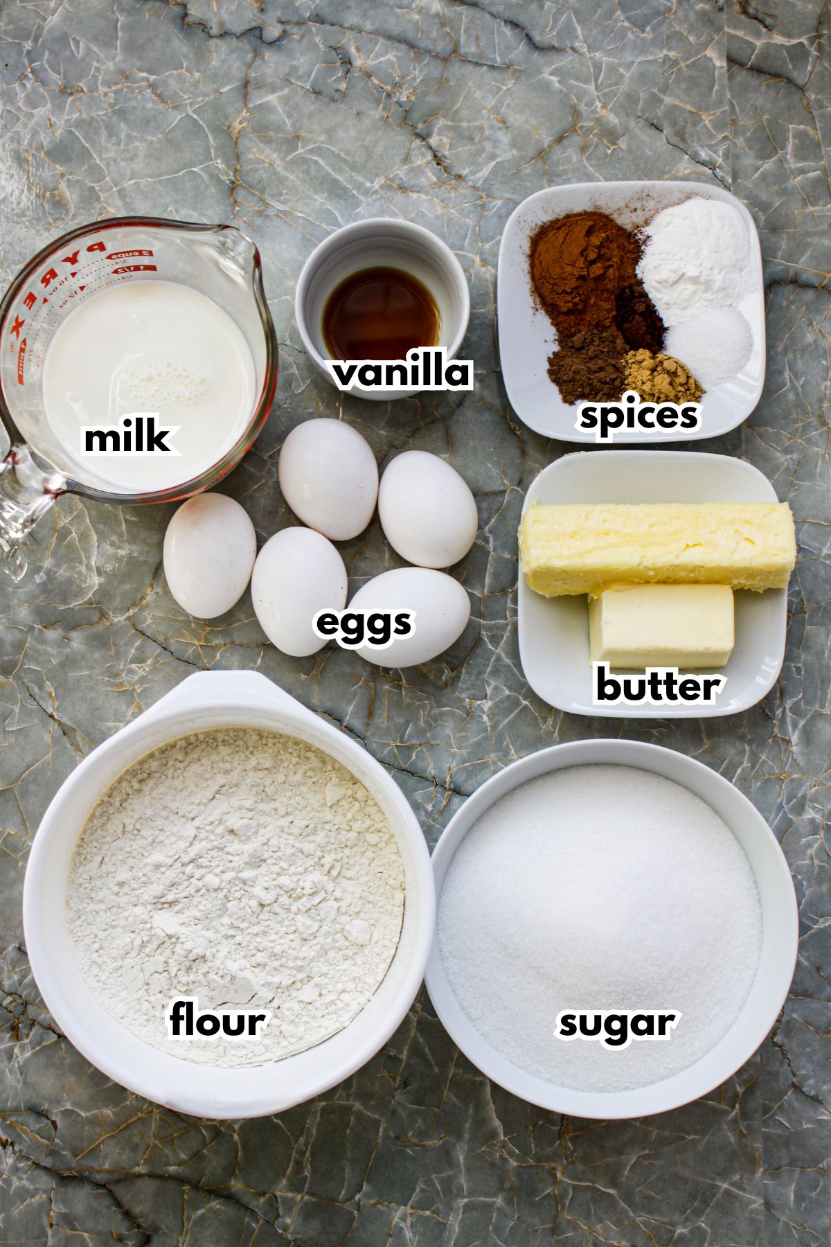 bowls of milk, vanilla, spices, eggs, butter, flour, and sugar.