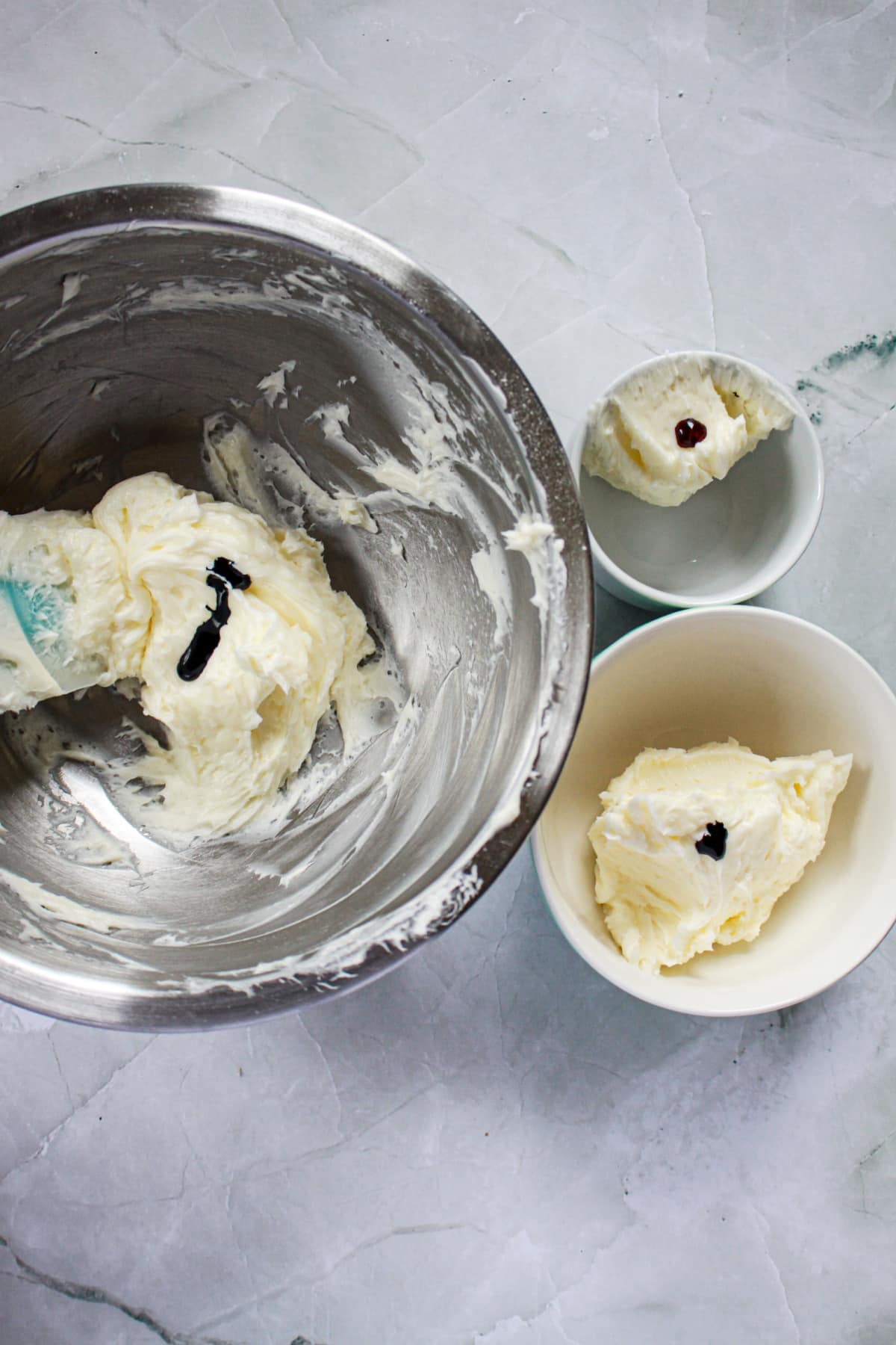 bowls of frosting being colored with food coloring.