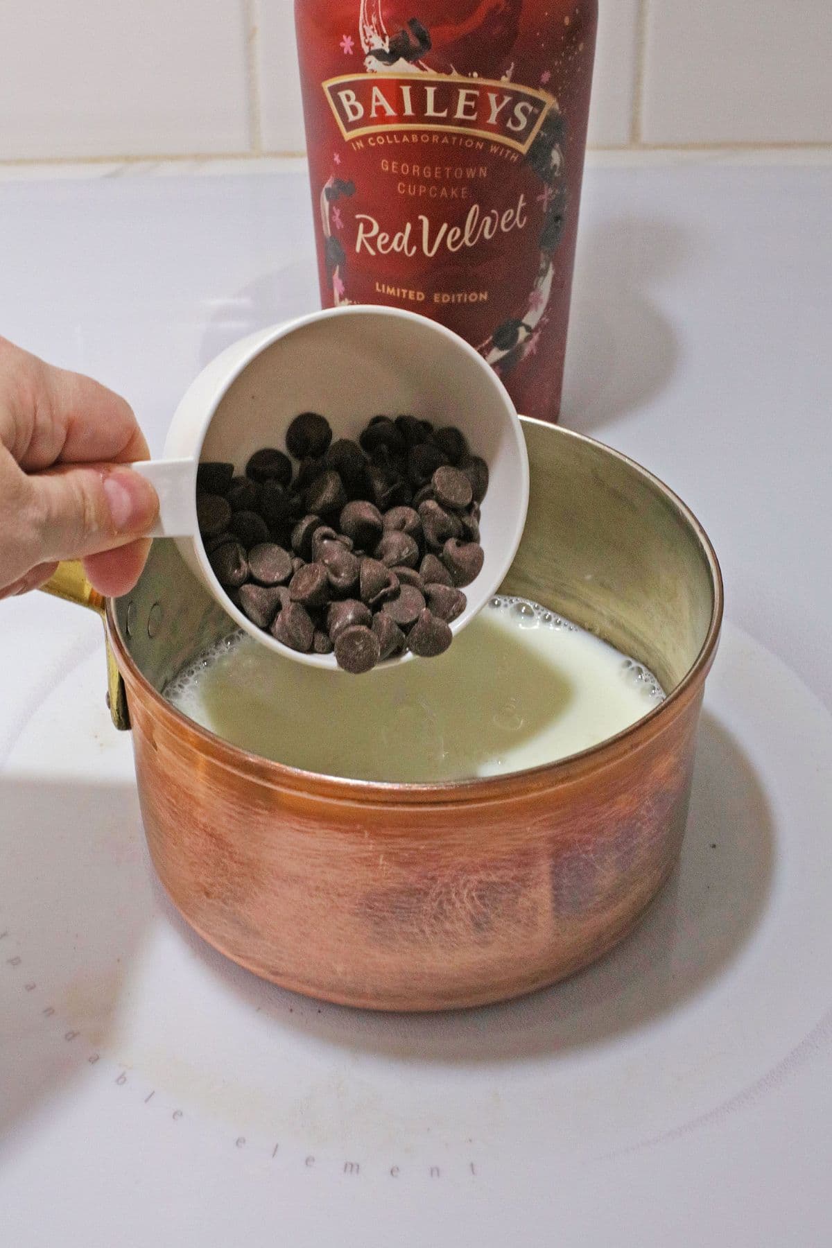 chocolate chips and milk being heated in a saucepan.
