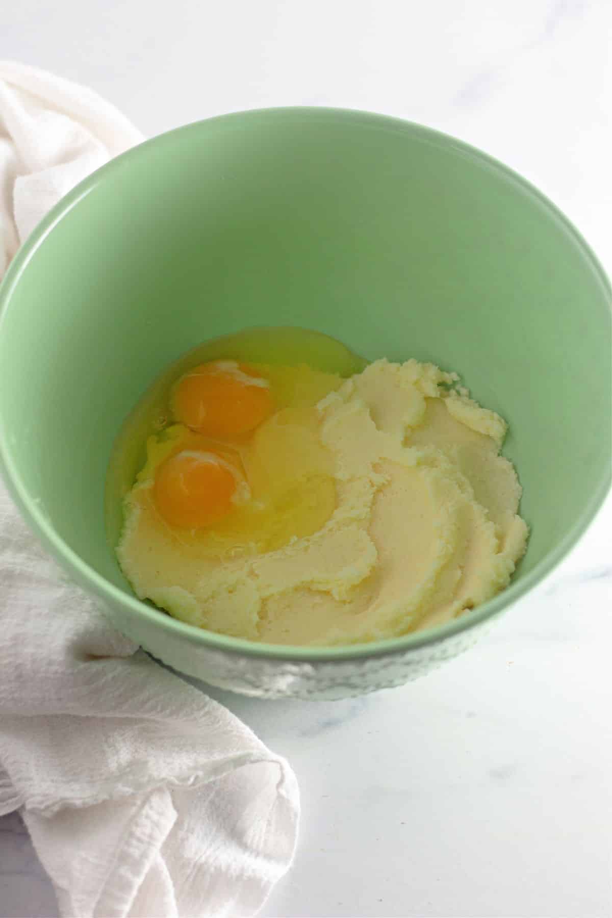 butter, sugar, and eggs being in a mixing bowl.