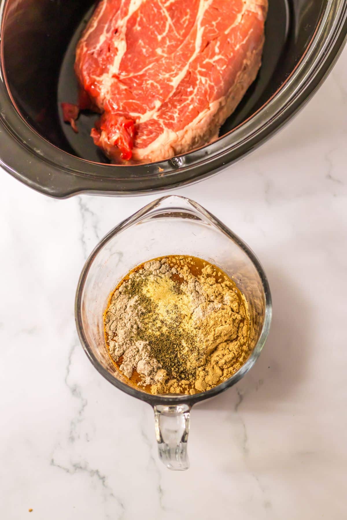 au jus and gravy being mixed with beef broth in a measuring cup.