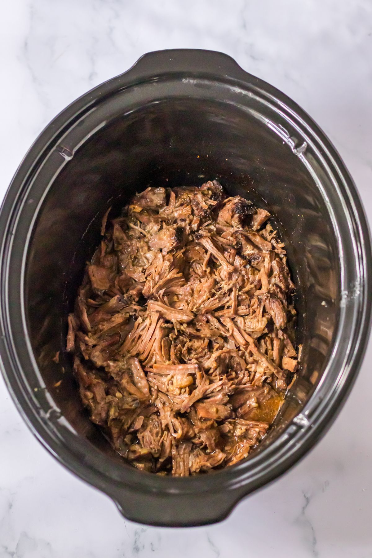 cooked shredded beef in a slow cooker.