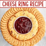 cheese ring on a platter with jam in the center and crackers on the outside.