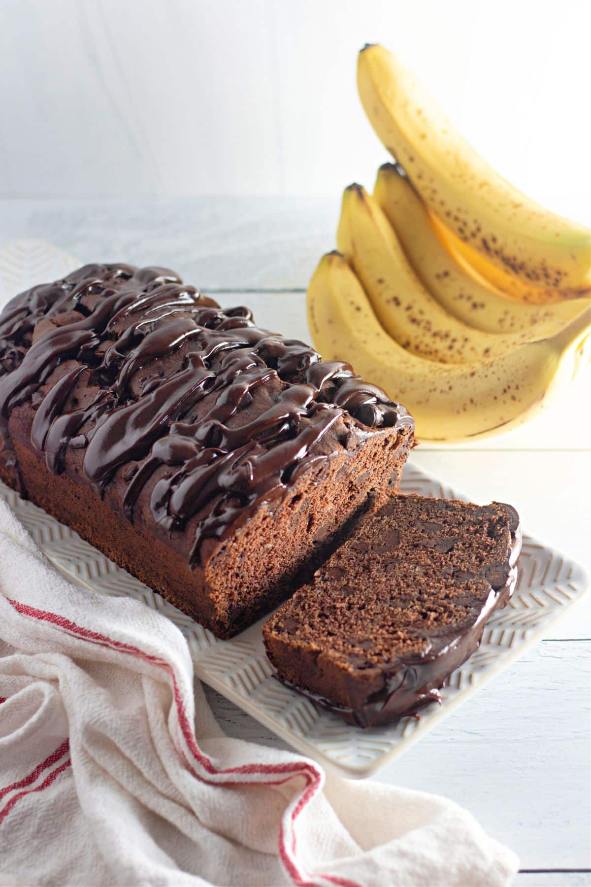 loaf of triple chocolate banana bread with a slice cut.