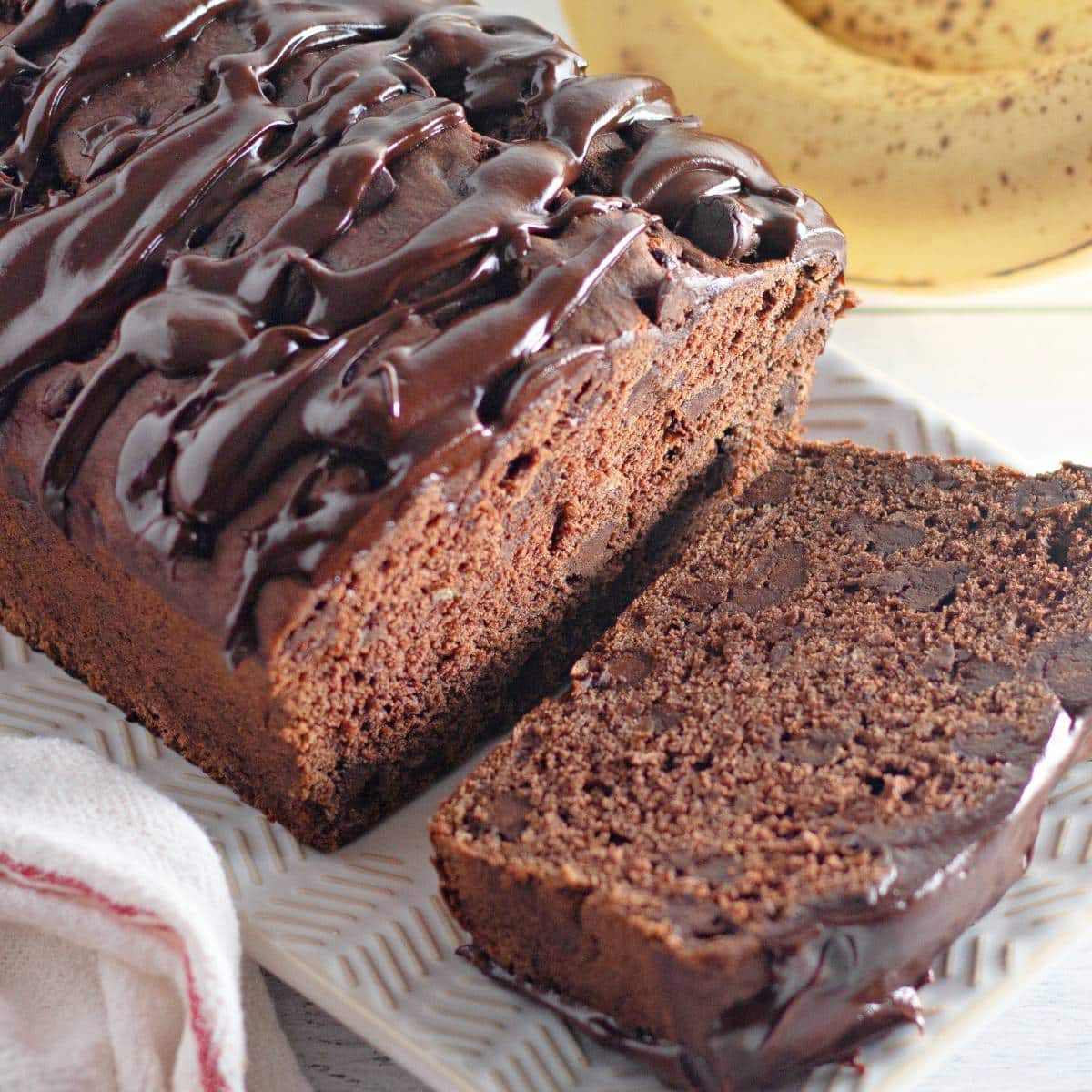 loaf of triple chocolate banana bread with a slice cut.