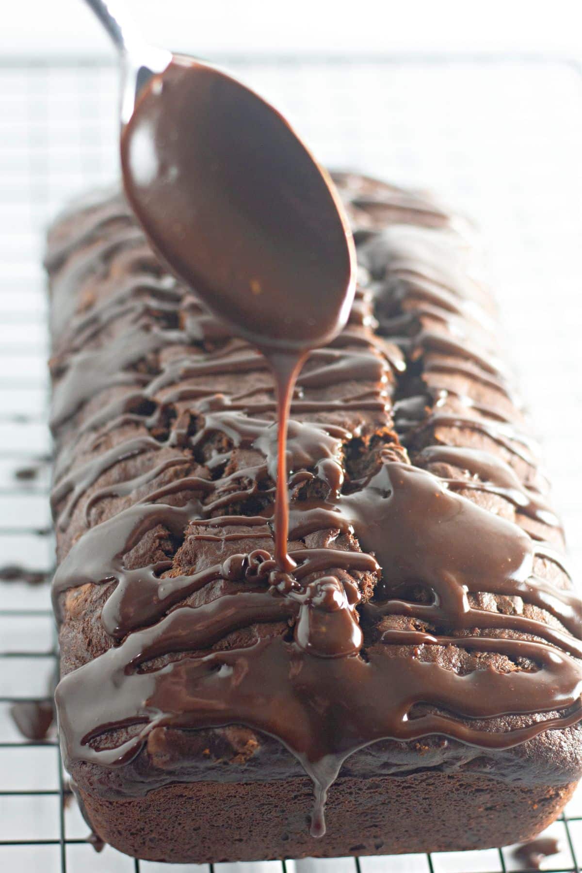 chocolate ganache being drizzled over banana bread.