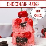 two slices on chocolate cherry fudge on a plate topped with a fresh cherry.