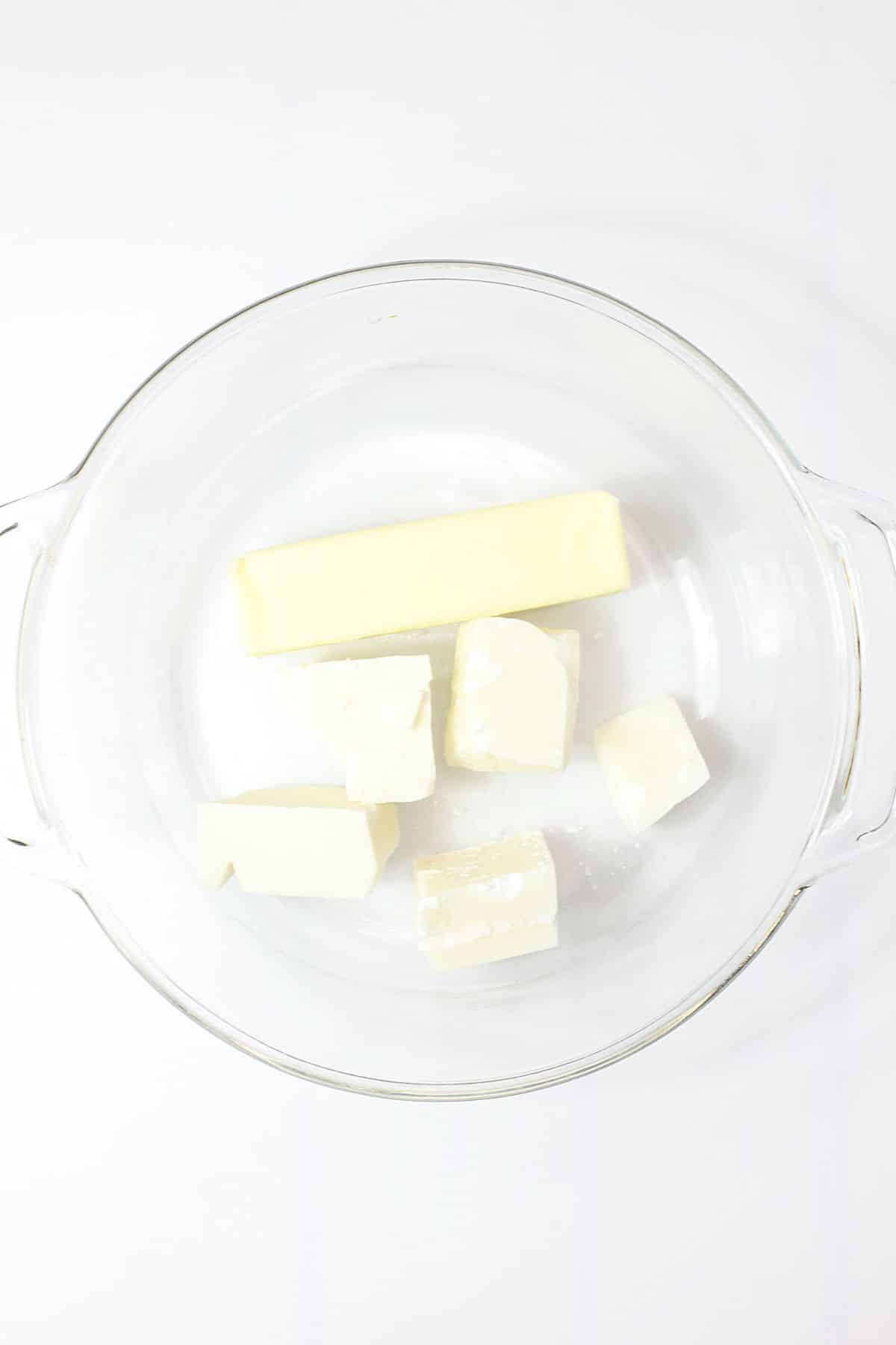 butter and white chocolate chunks in a glass bowl ready to be melted in the microwave.