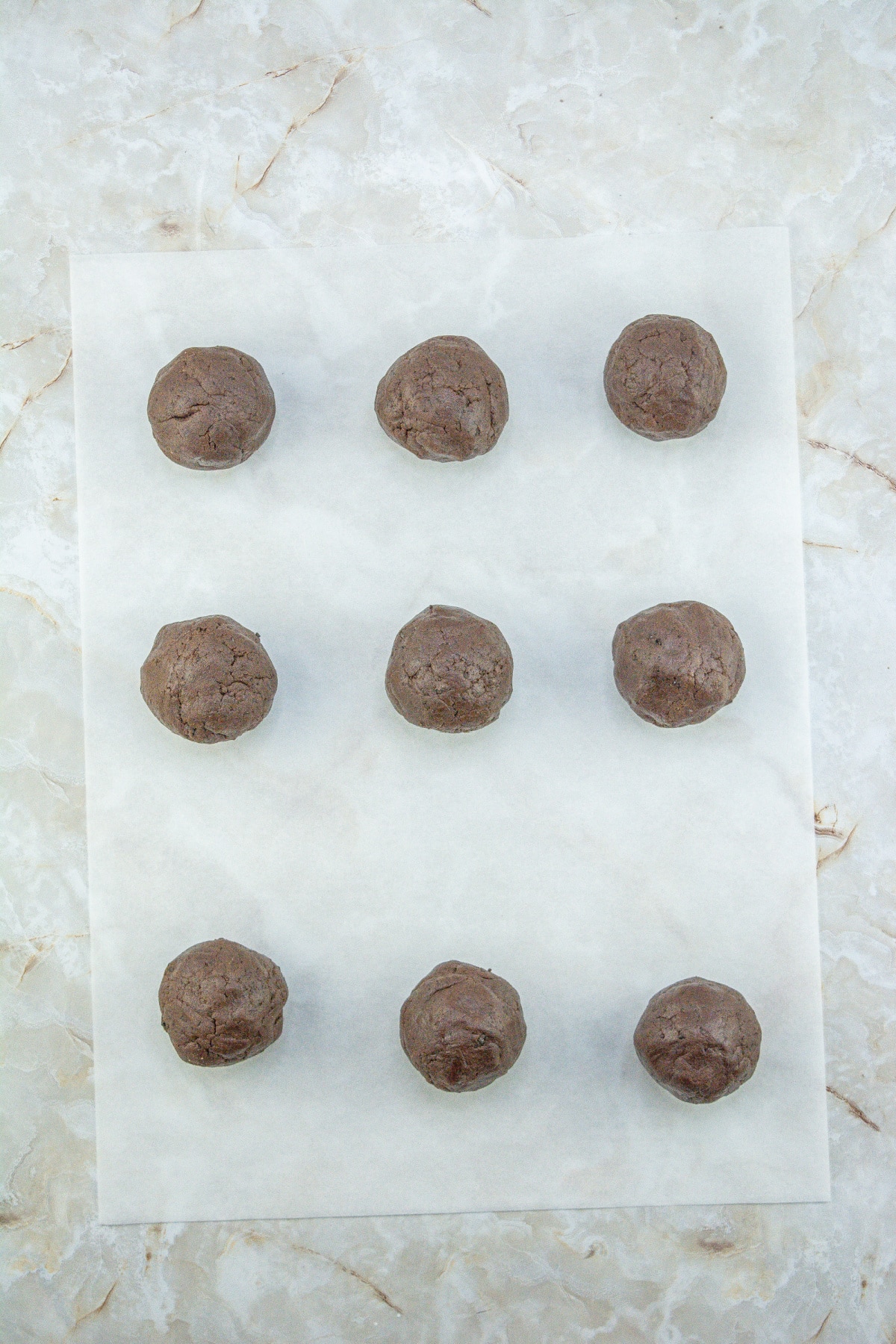 cookie dough balls on a piece of parchment paper.
