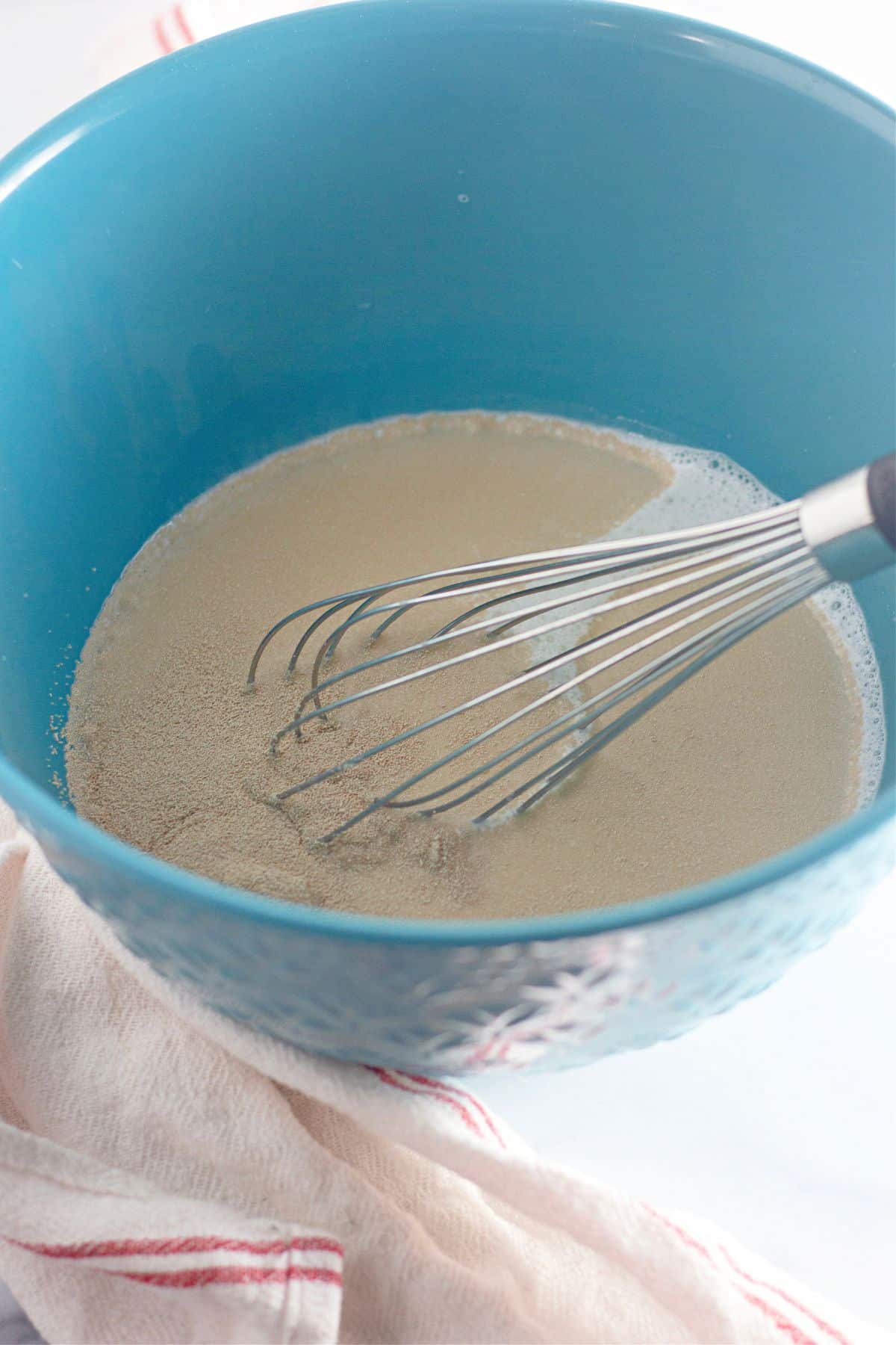 yeast, sugar and milk in a mixing bowl.
