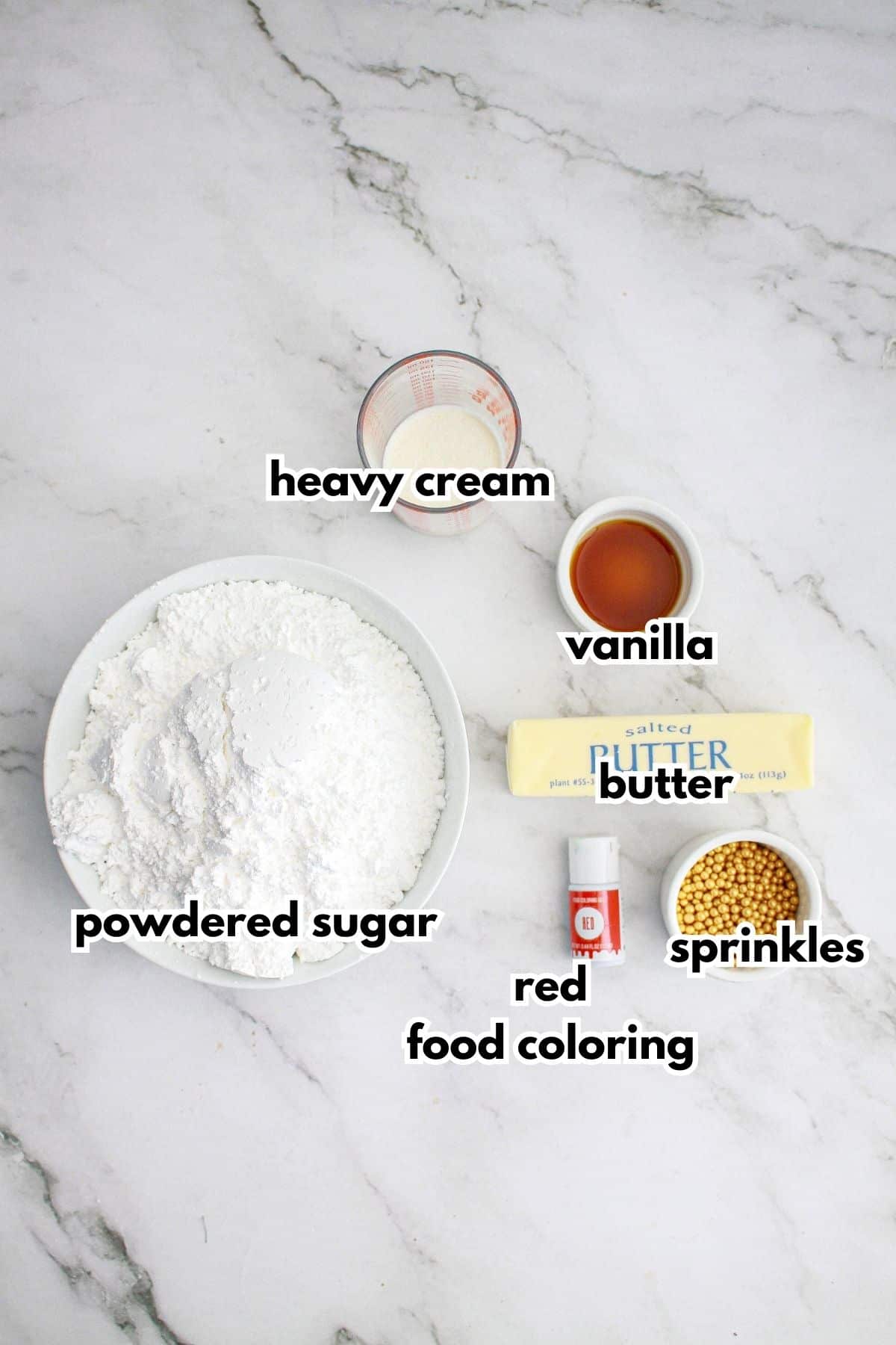 bowls of powdered sugar, heavy cream, vanilla, butter, sprinkles, and red food coloring.