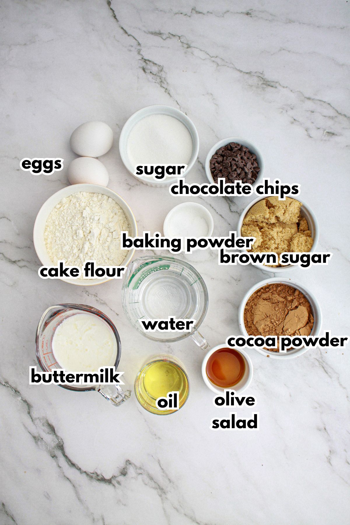 ingredients needed to make devils food cupcakes in bowls on a small counter.