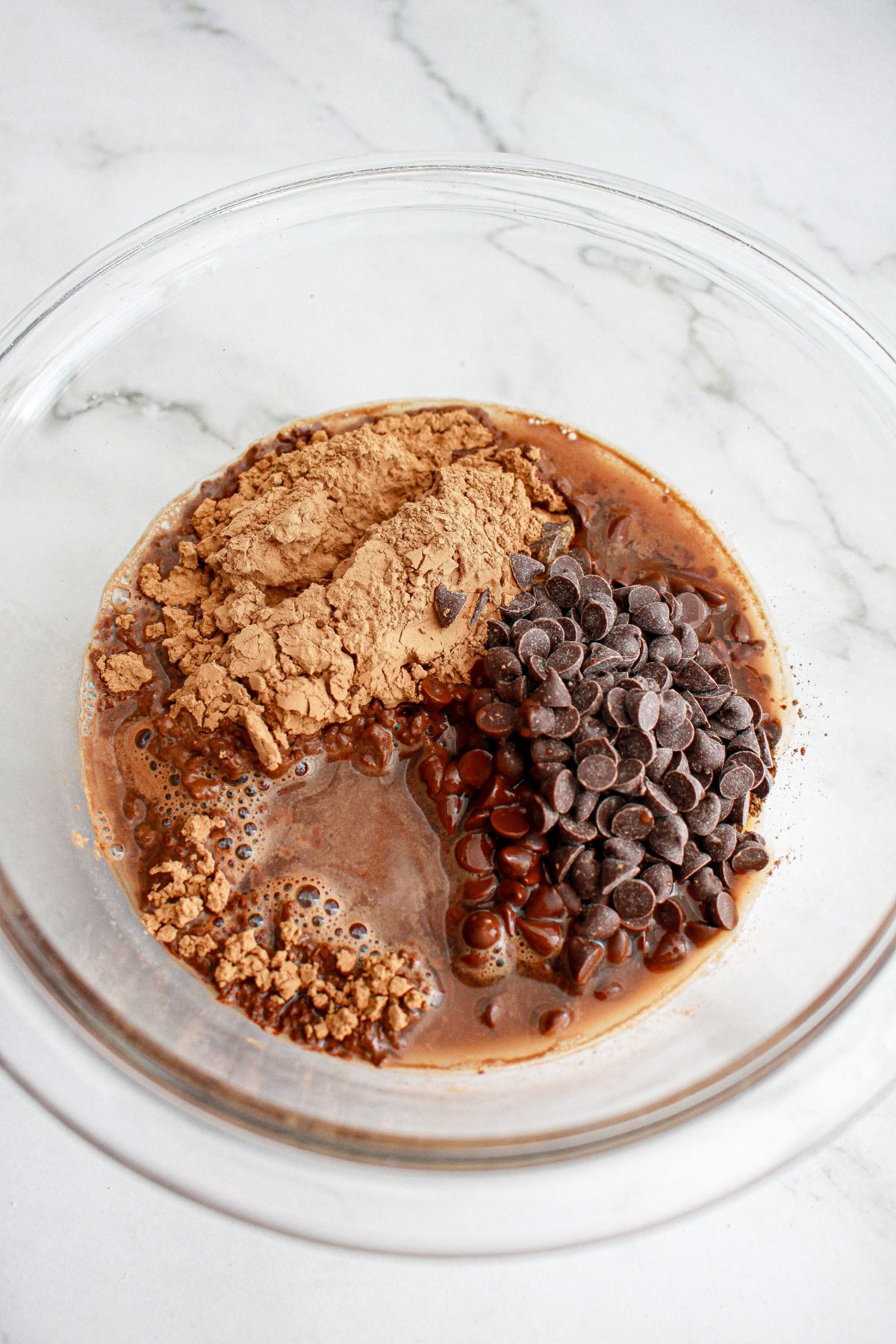 chocolate chips, cocoa powder, and boiling water in a glass bowl.