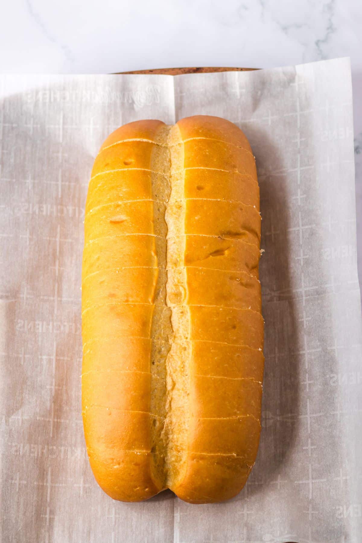 loaf of bread being sliced on a baking sheet.