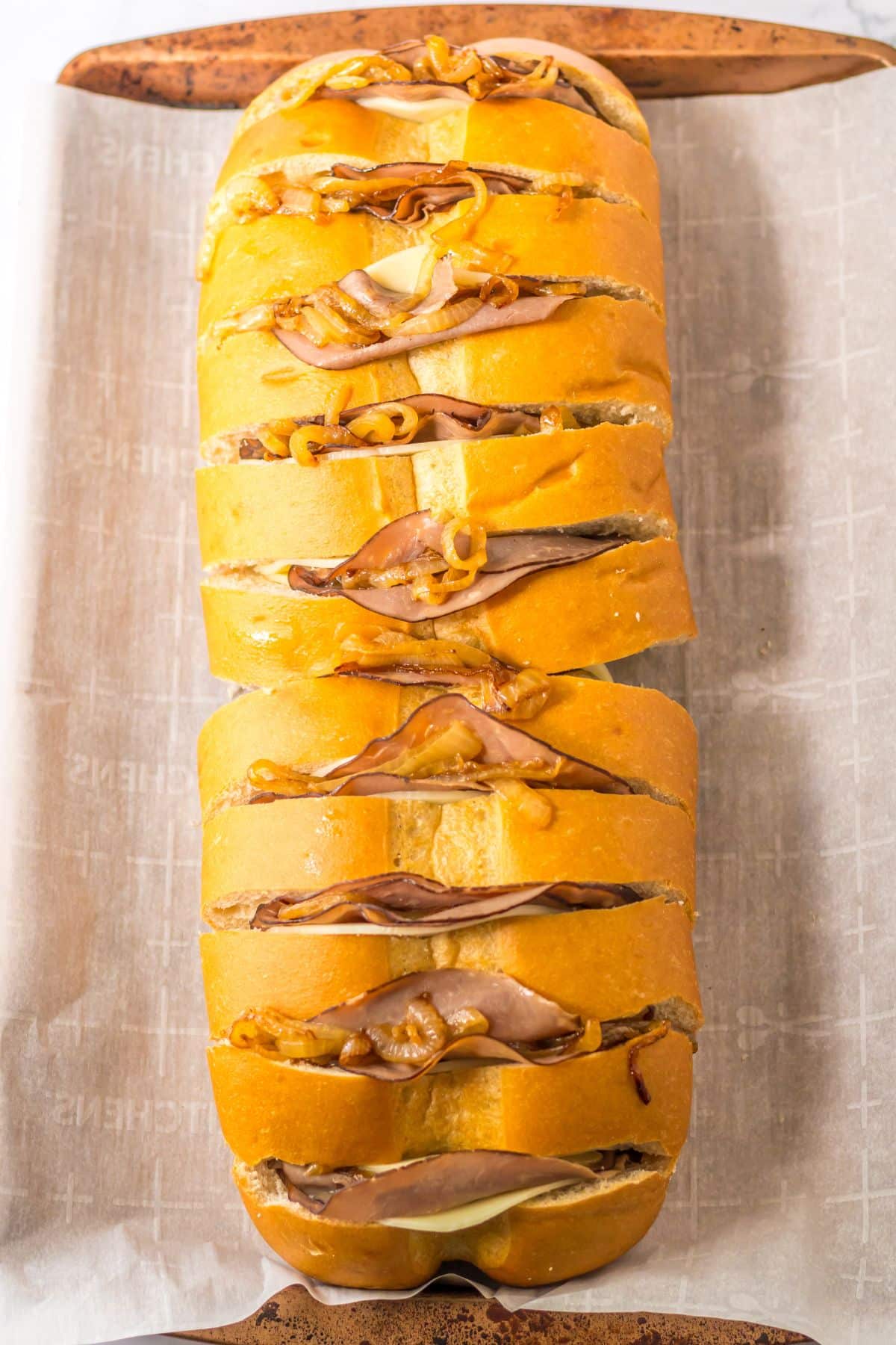 roast beef, cheese, and peppers being stuffed between bread slices.