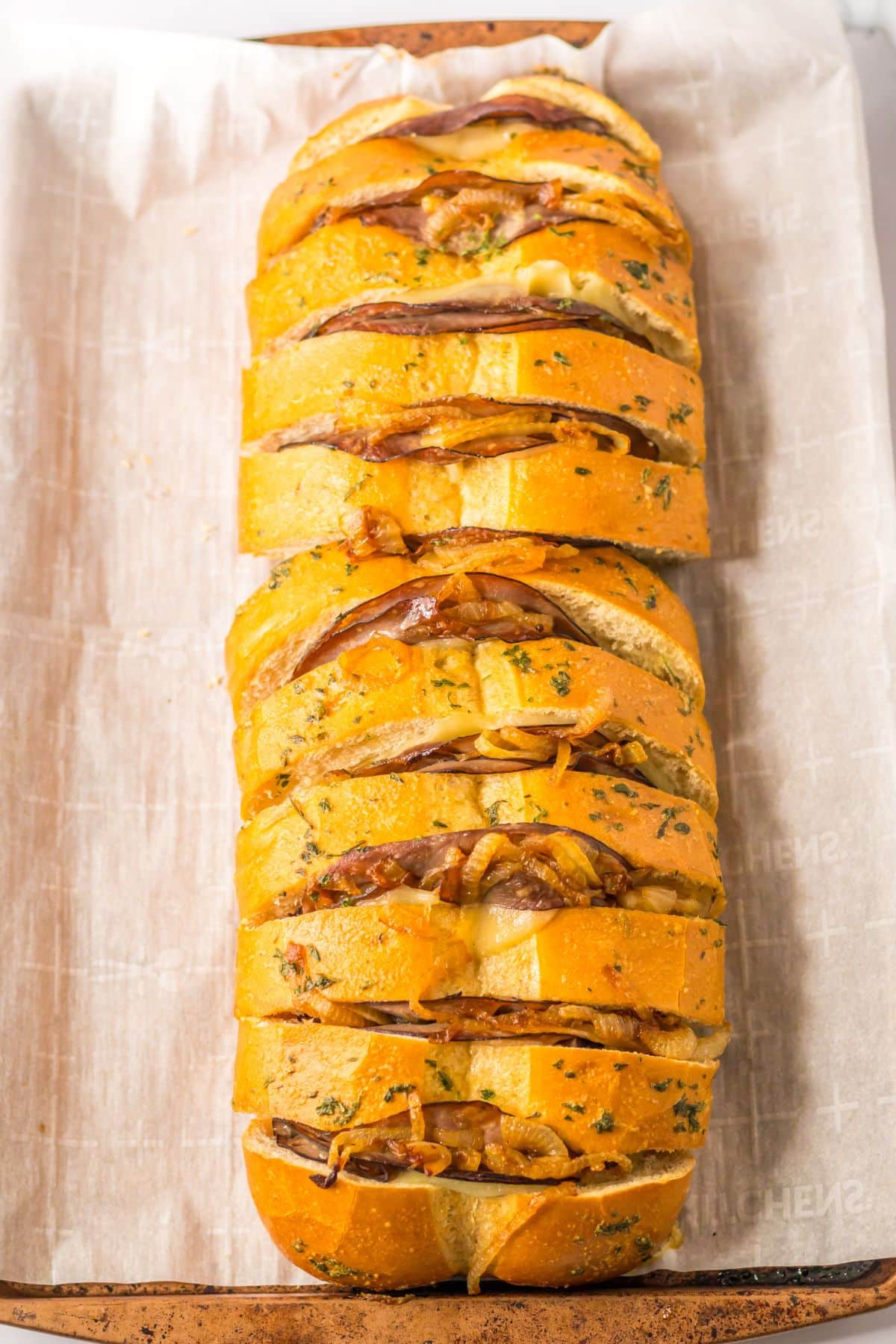 baked french dip pull apart bread on a parchment lined baking sheet.