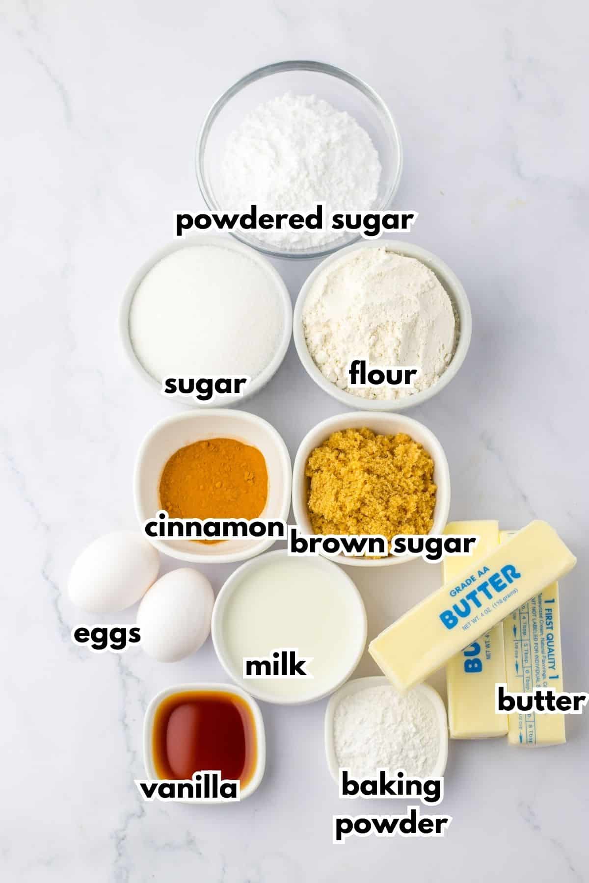 bowls of powdered sugar, sugar, flour, cinnamon, brown sugar, eggs, milk, vanilla, baking powder, and butter.