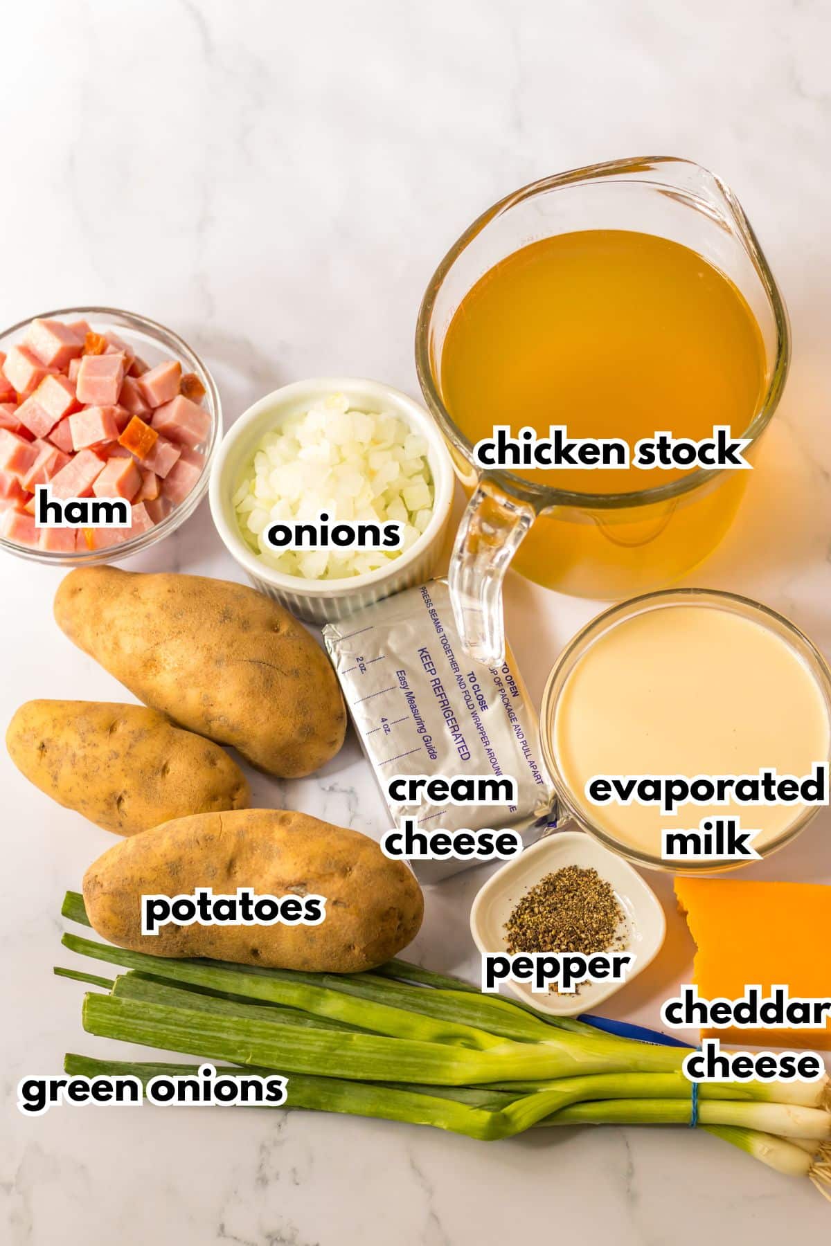 bowls of ham, onions, chicken stock, cream cheese, evaporated milk, potatoes, pepper, cheddar cheese, and green onions.