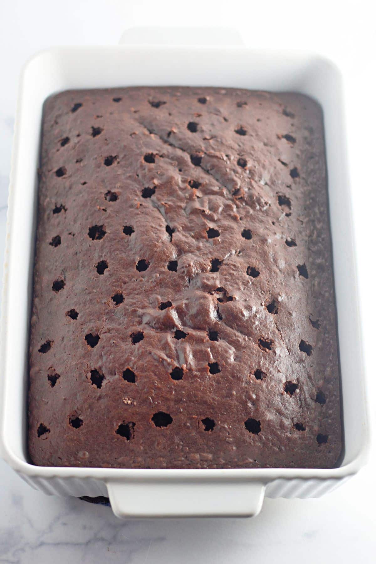 holes being punched into a chocolate cake.