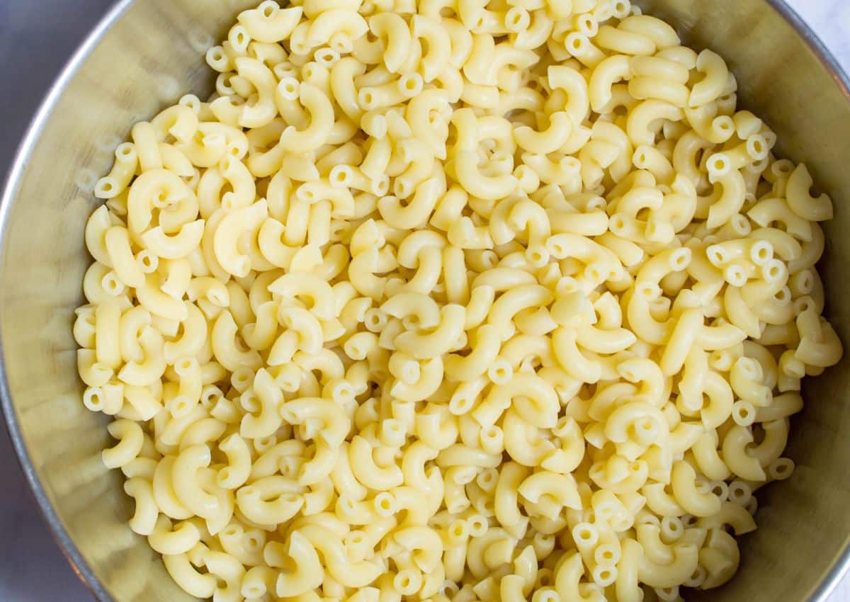 cooked pasta in a large stainless steel mixing bowl.