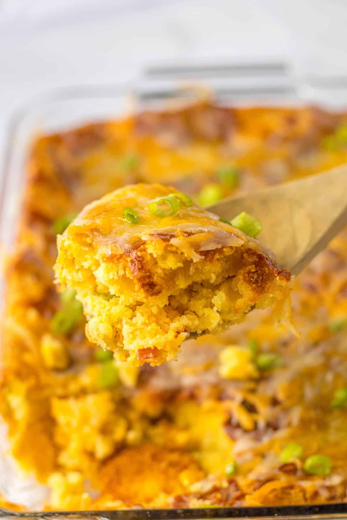 spoonful of loaded cornbread casserole held in the air.