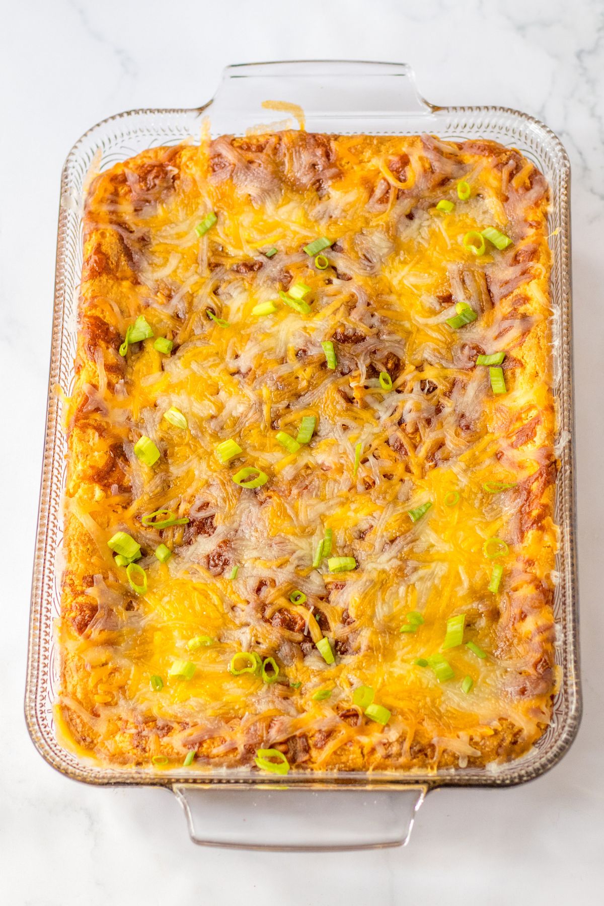 baked loaded corn casserole in a glass baking dish.