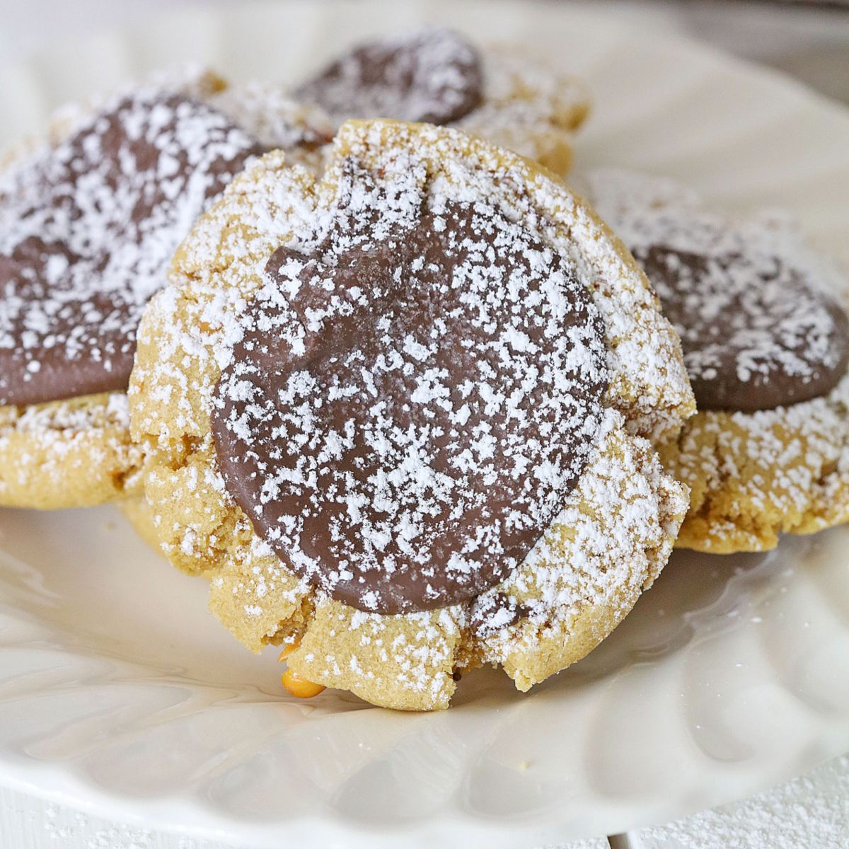 four muddy buddy cookies on a plate.