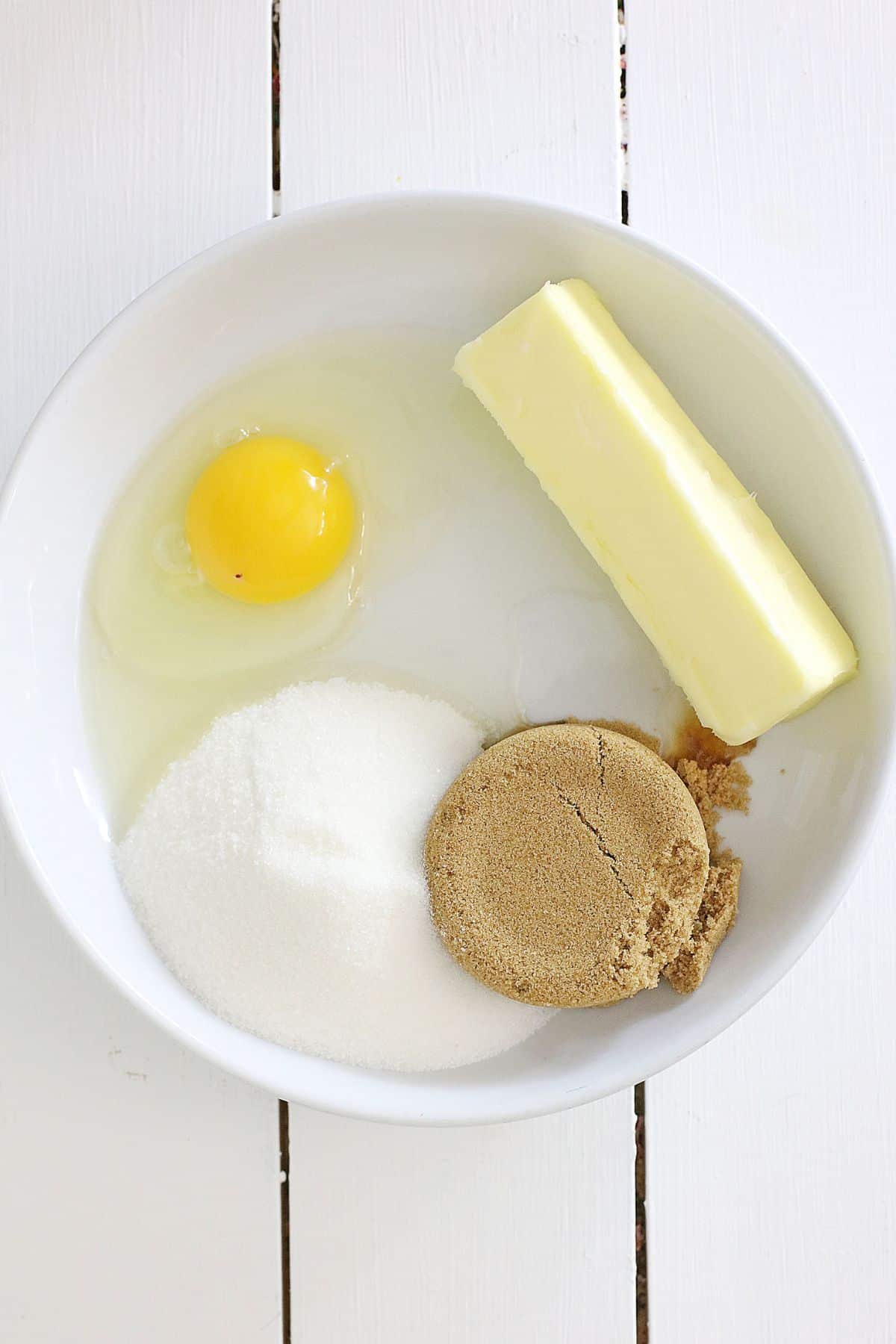 bowl filled with butter, sugar, brown sugar, and an egg.