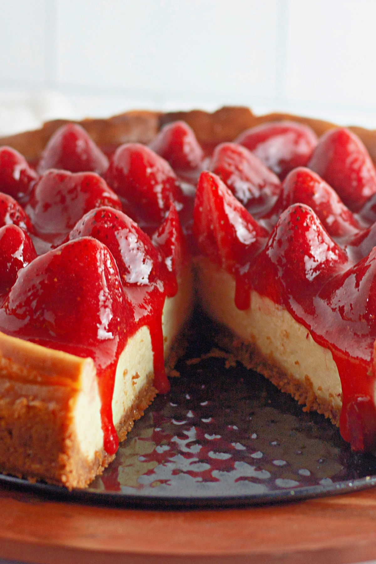 full cheesecake with a slice missing on a springform pan.