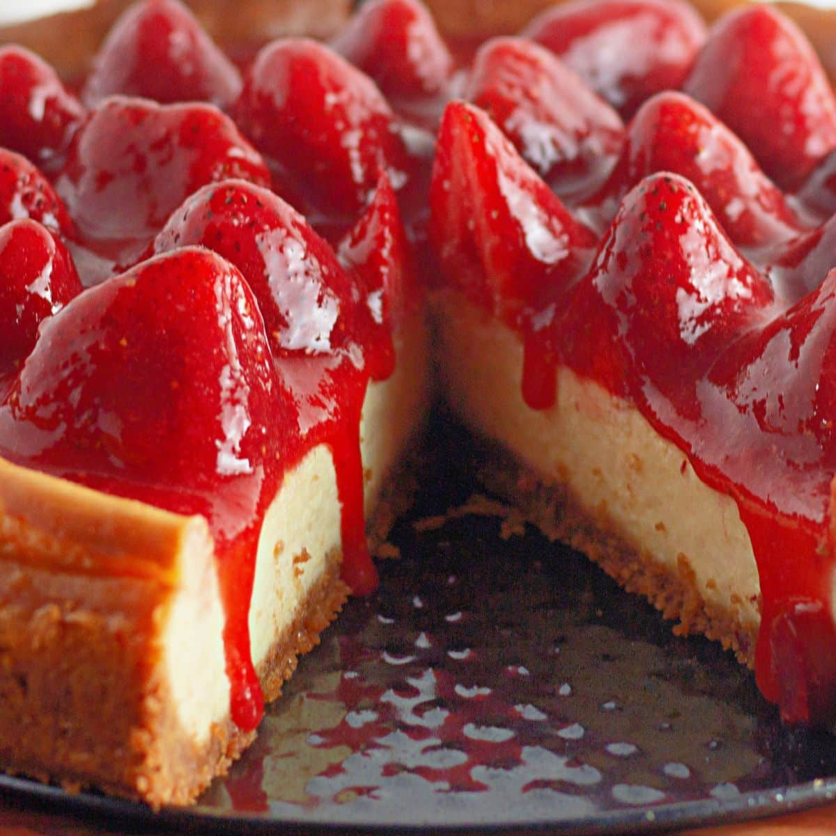 full cheesecake with a slice missing on a springform pan.