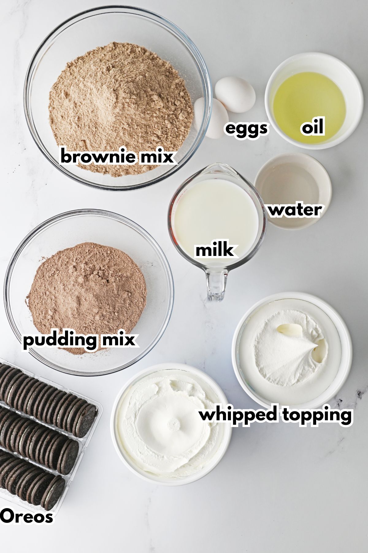 bowls of brownie mix, eggs, oil, water, milk, pudding mix, whipped topping, and oreos.