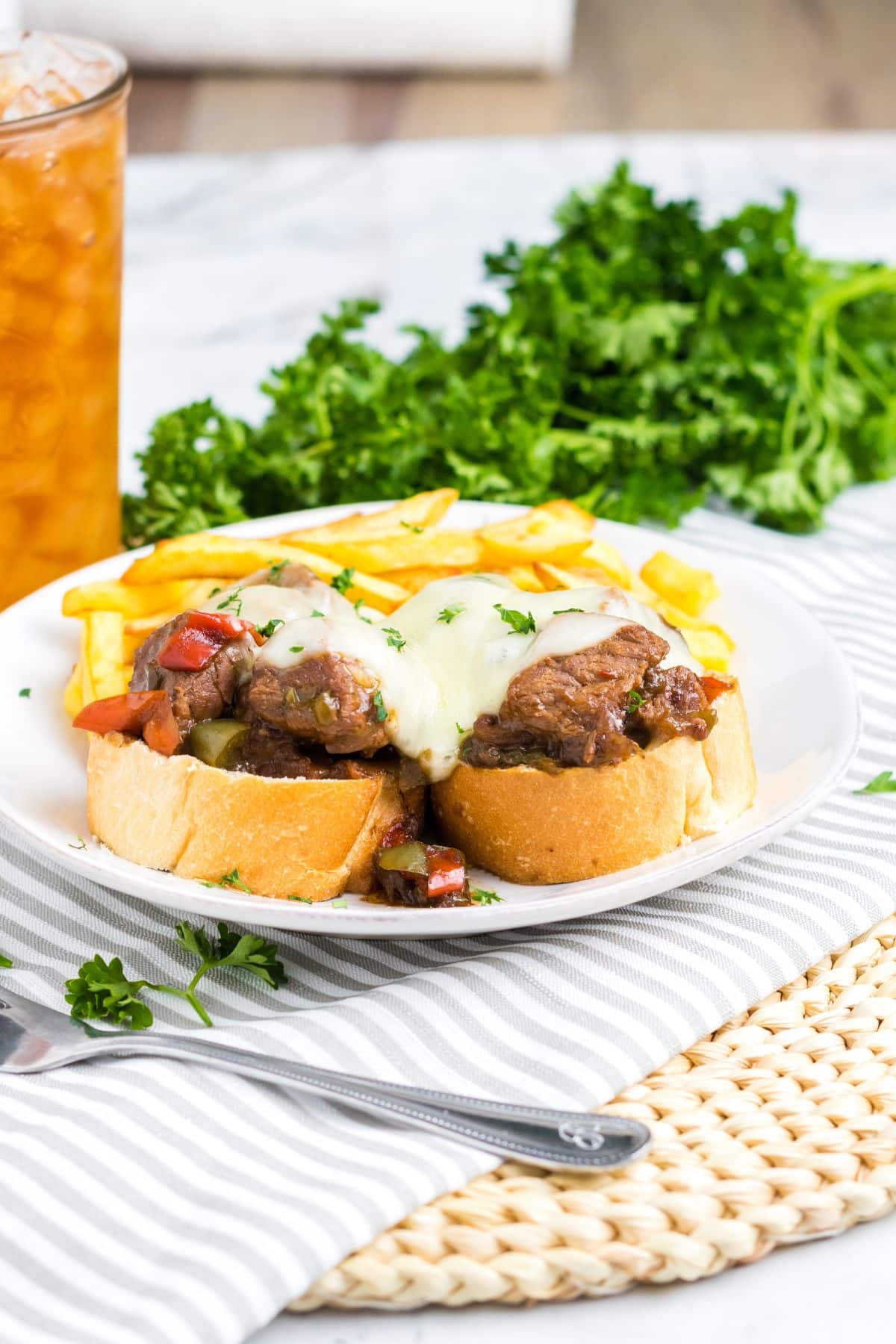 slow cooker philly cheesesteak bites on top of bread slices on a plate.