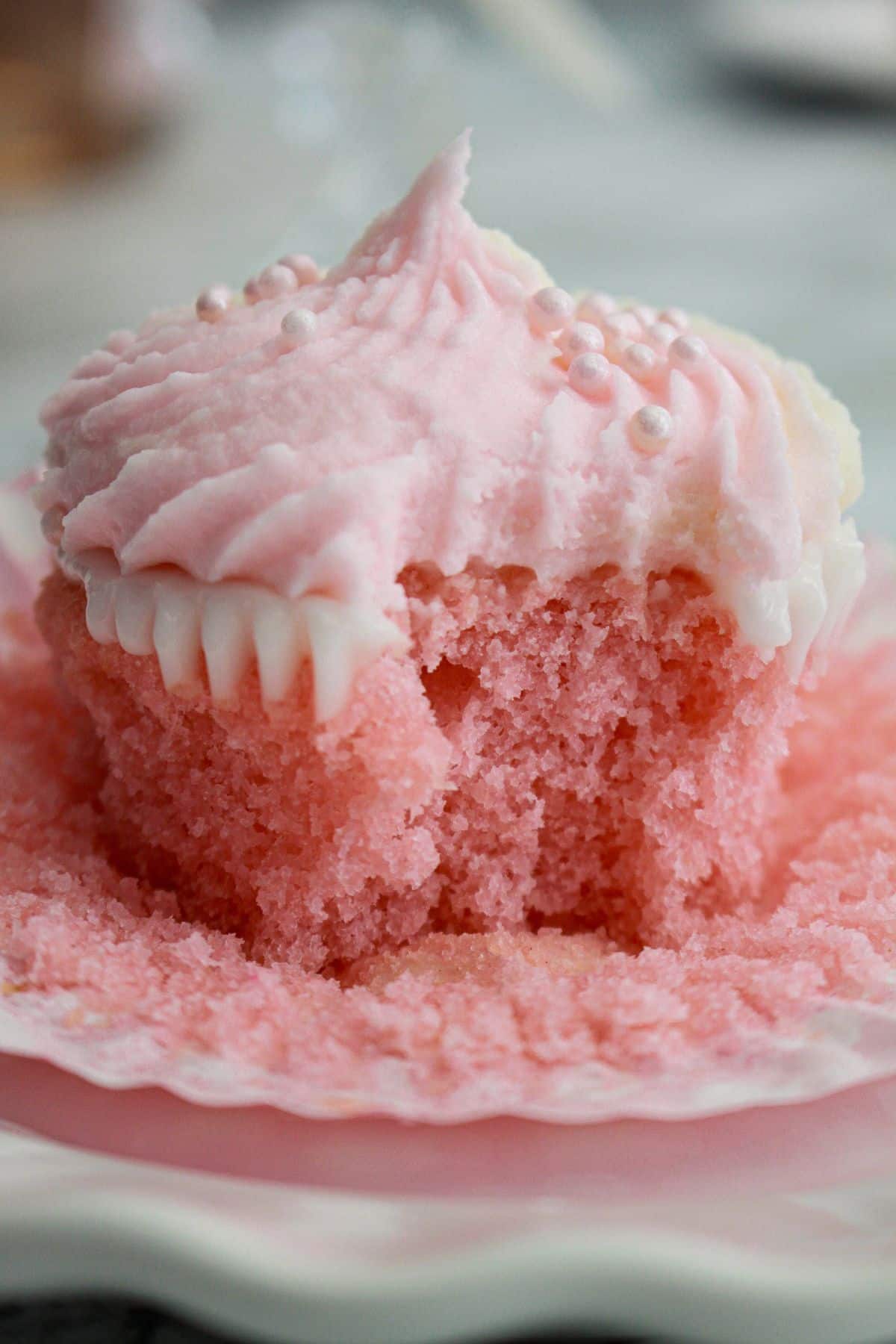 pink champagne cupcake on a marble counter.