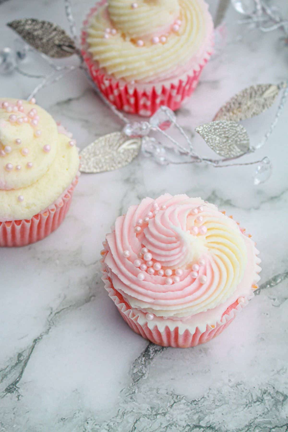 pink champagne cupcake on a marble counter.